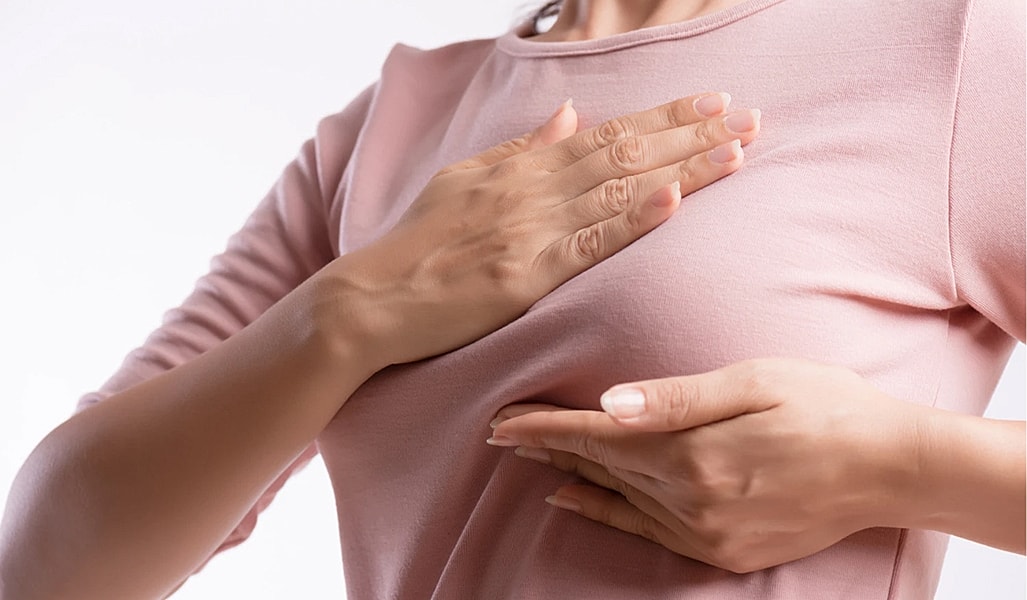 Woman performing breast self-exam technique.